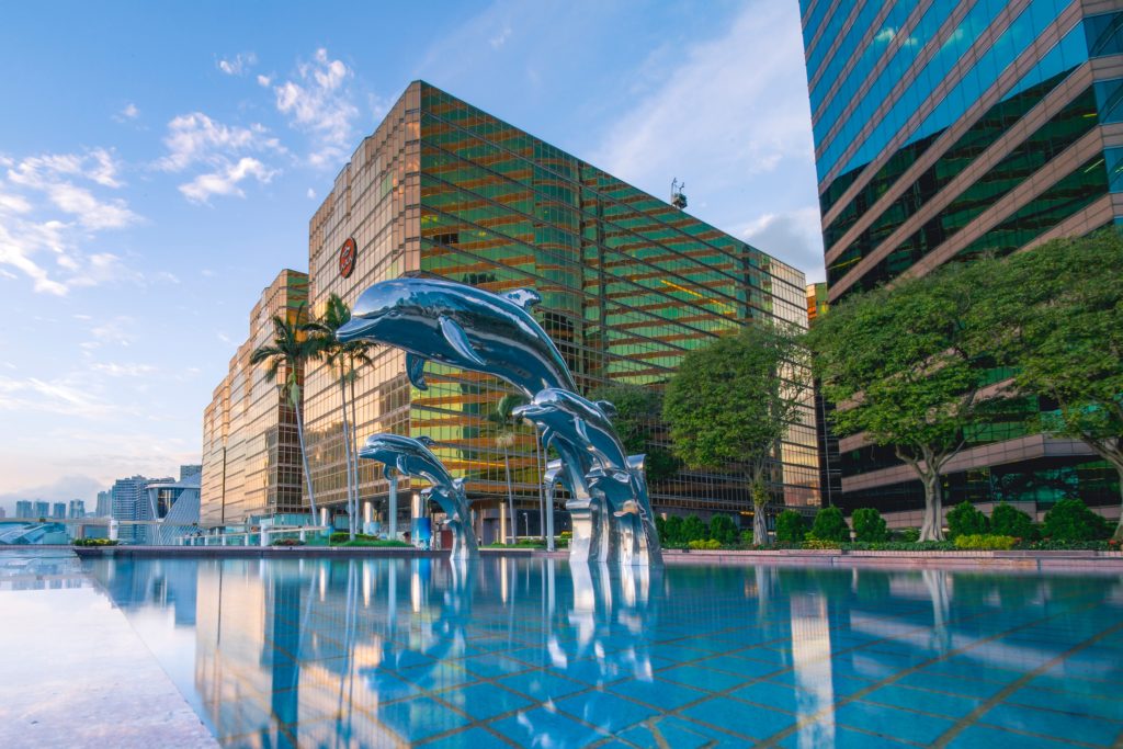 three-blue-dolphins-statue-front-of-water-near-building-1458457